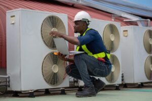 technician performing a scheduled inspection on rooftop HVAC units