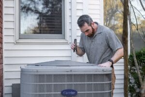 Technician performing maintenance on an outdoor HVAC unit at an office building